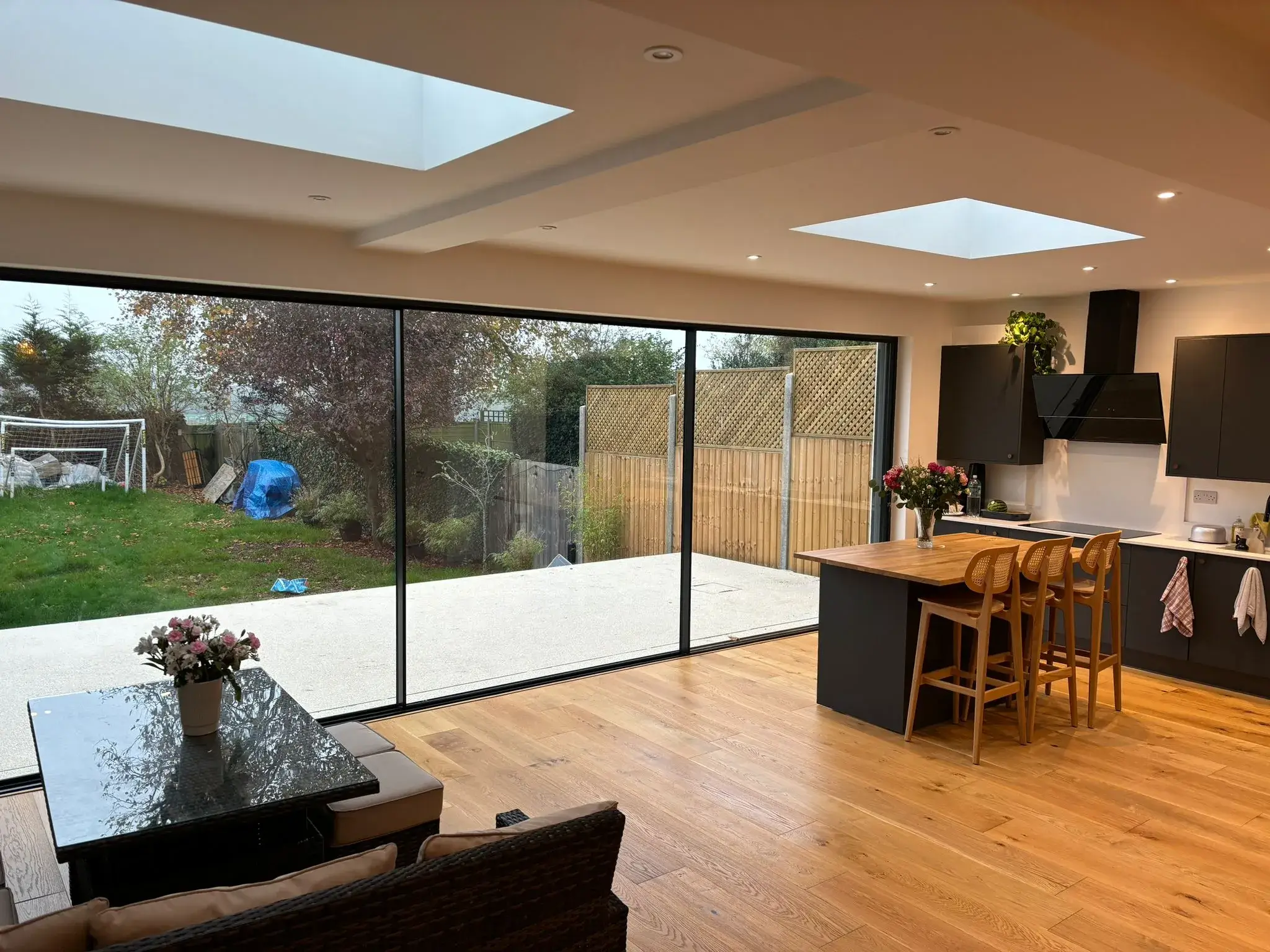 A kitchen with a table and chairs next to a sliding glass door.