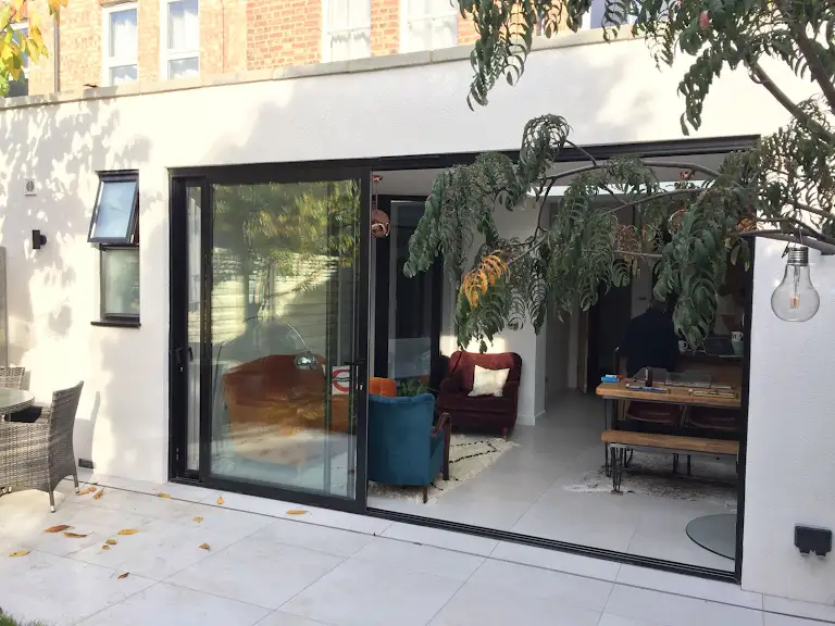 A patio with a couch, table and chairs.