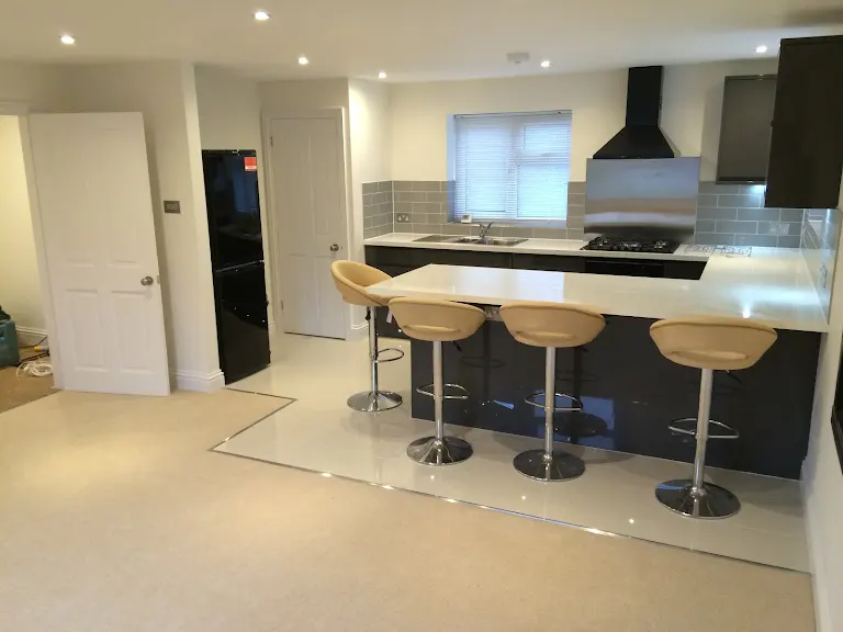 A kitchen with a bar and stools in it.